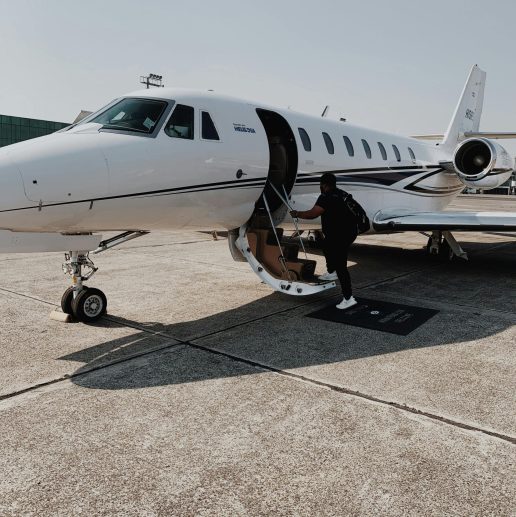 Person boarding a private jet at an airport in Guatemala City on a sunny day.